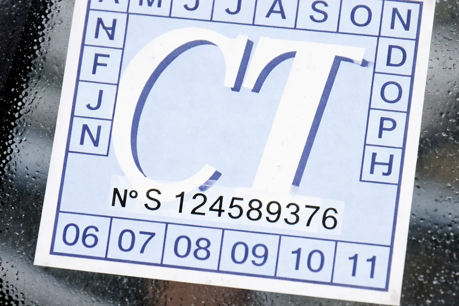 Vignette de contrôle technique CT collée sur le pare-brise d'une voiture